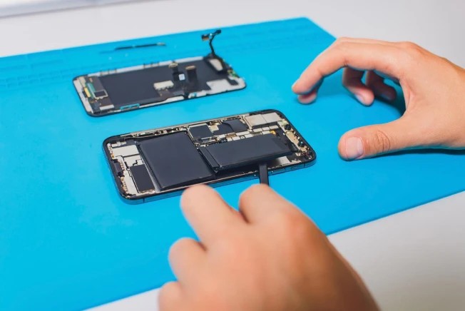 Técnico da Ev Start Tech trocando a bateria de um celular